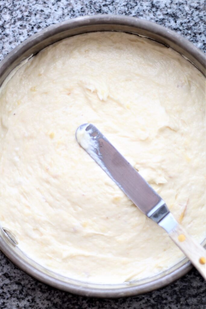 smoothing cake batter in pan with offset spatula