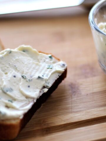 incredible chive spread on wooden board with sliced bread