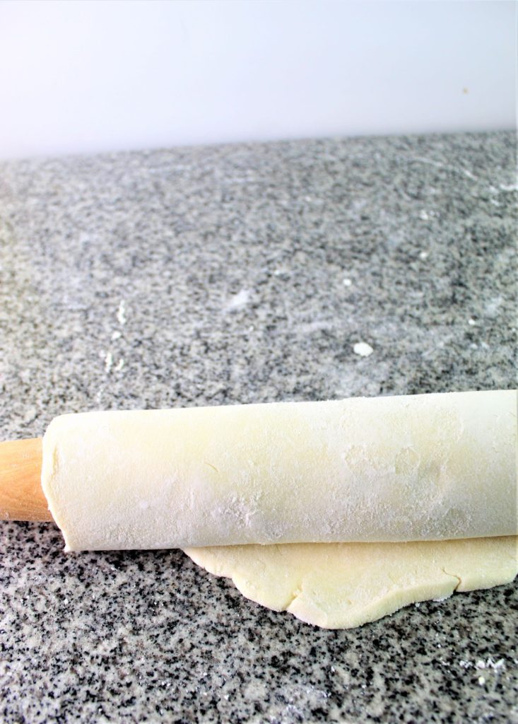 rolling up the pie dough onto the rolling pin