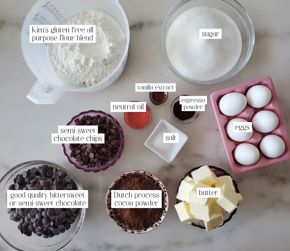 sheet pan brownies ingredients measured out and labeled on marble countertop.