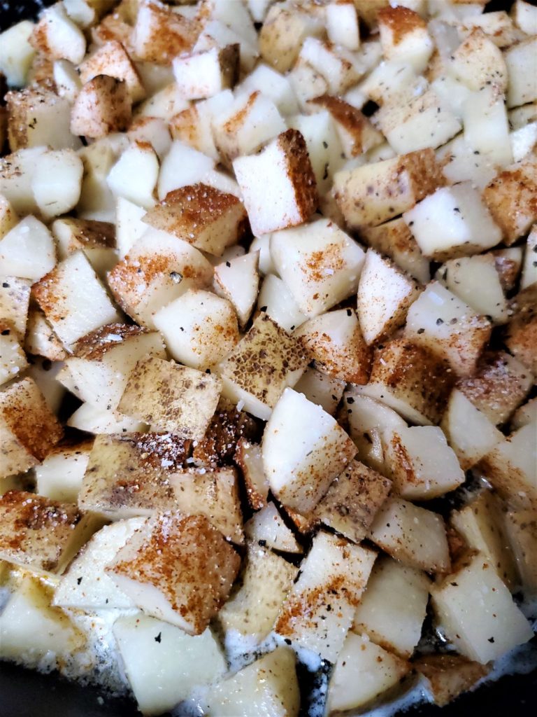 cubed potatoes in cast iron skillet