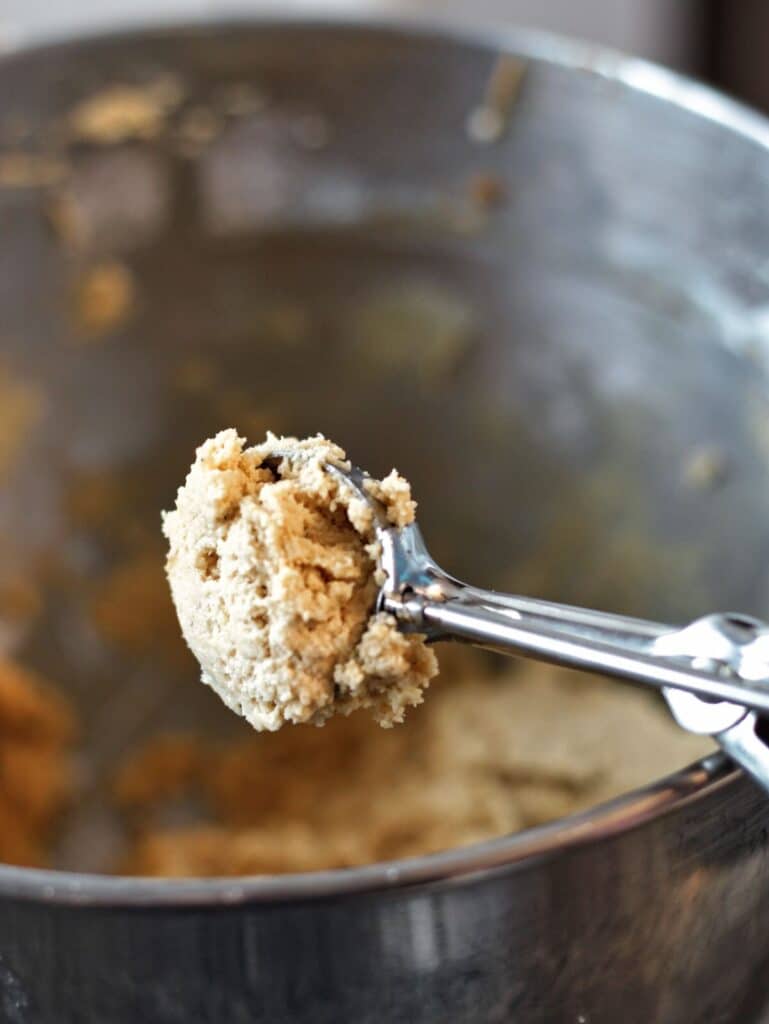 scooping peanut butter cookie dough using a cookie scoop.