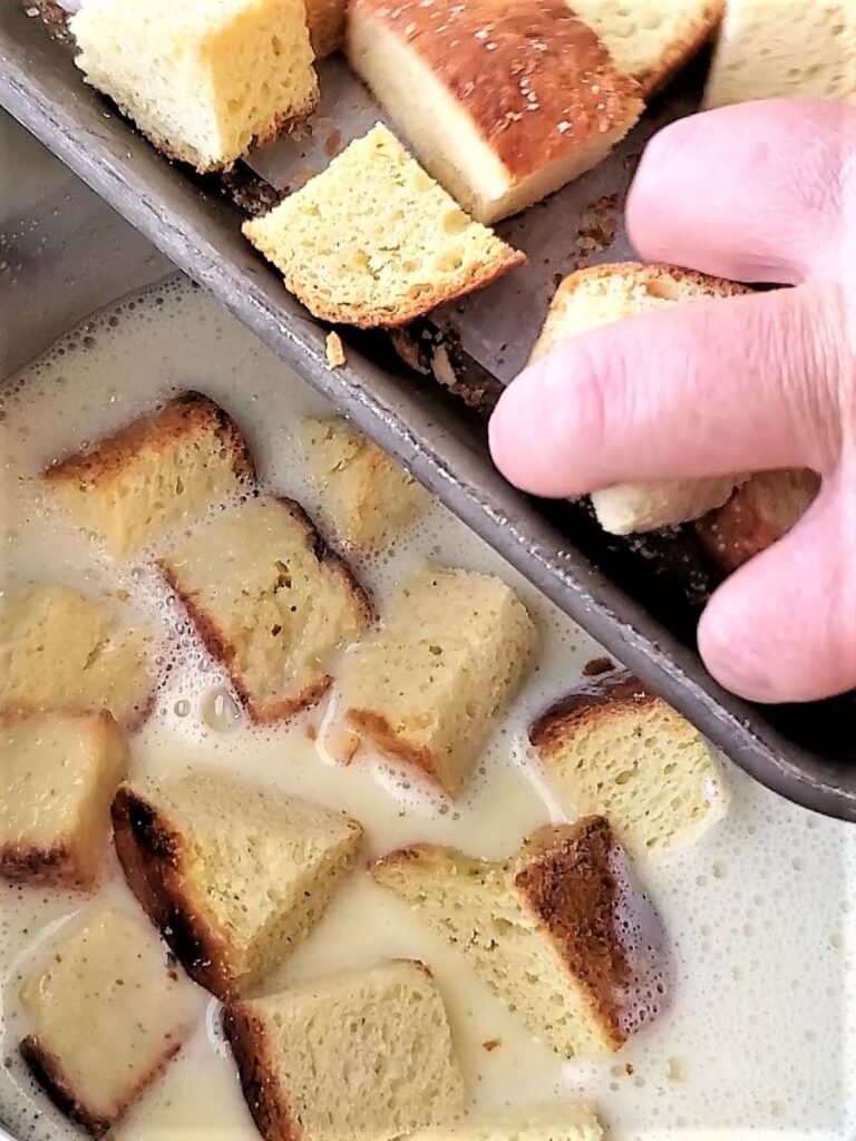 adding bread cubes into custard