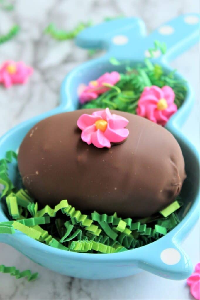 chocolate easter eggs in blue bunny dish with green easter grass