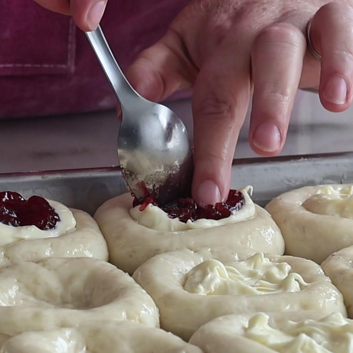 spooning fruit filling on top of cream cheese filling in center of rolls.