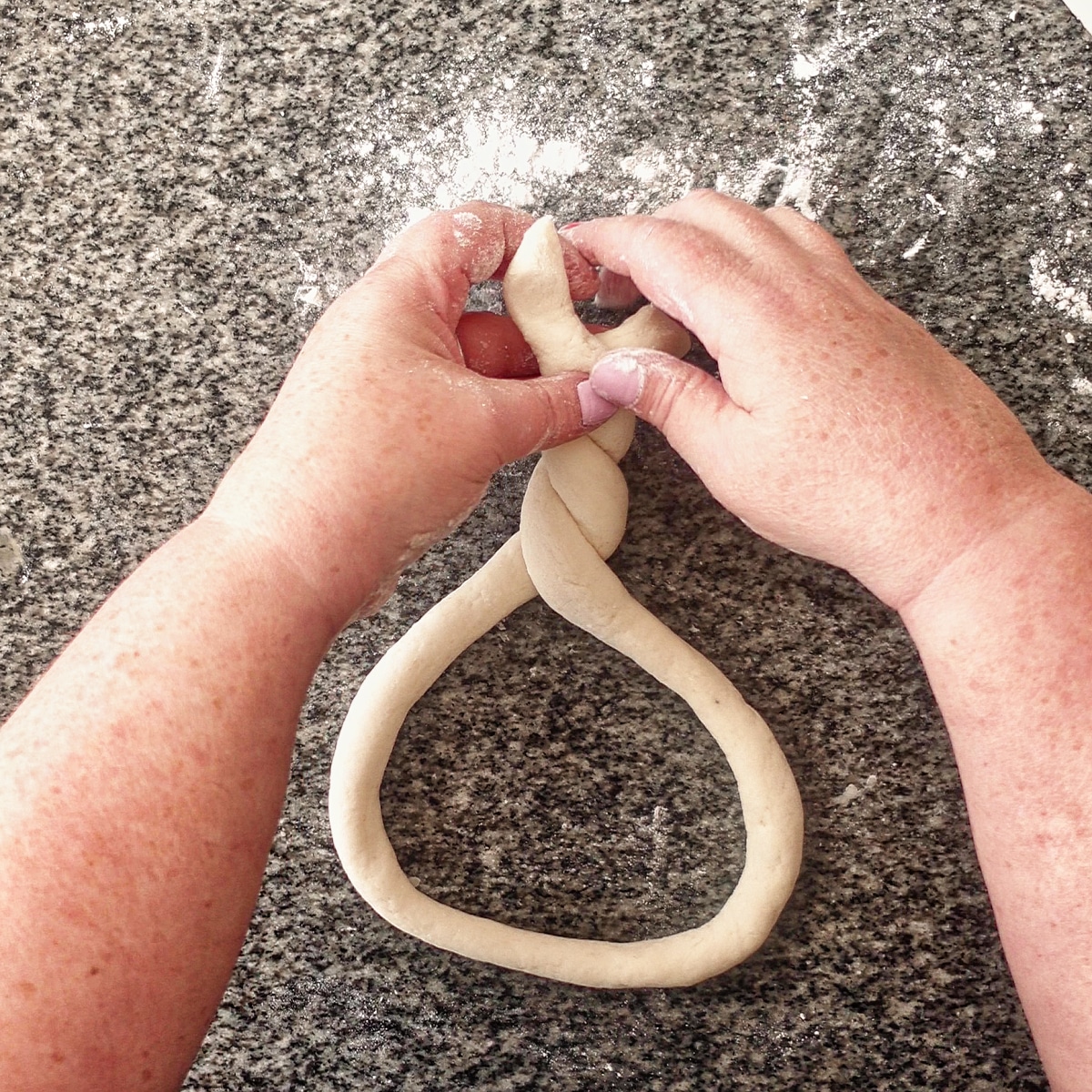 twisting the ends of the dough rope twice.