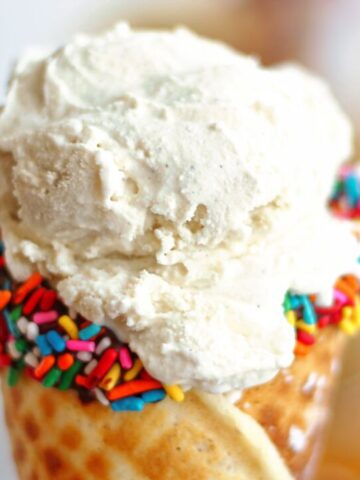 landscape view of gf waffle cone dipped in chocolate and colored sprinkles and filled with vanilla ice cream