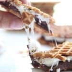 gluten free smores pizzelle sandwich pulled apart with melted marshmallow