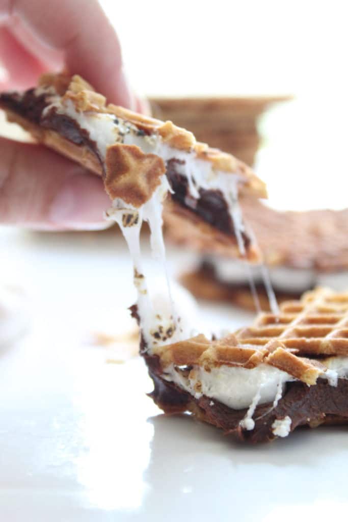 gluten free smores pizzelle sandwich pulled apart with melted marshmallow