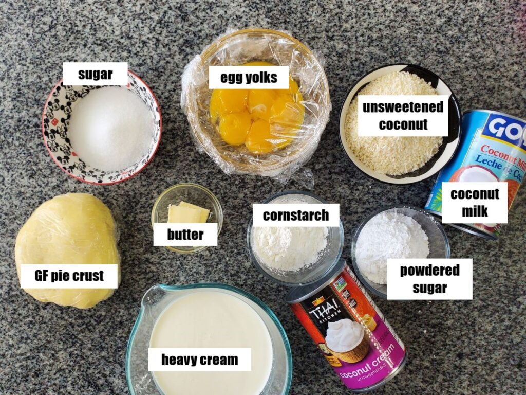 ingredients for coconut cream pie measured out and placed in individual bowls on granite countertop.