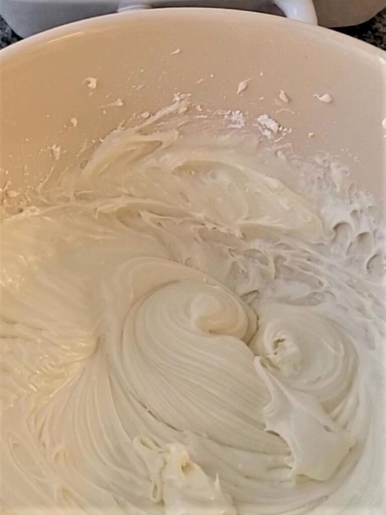 cream cheese frosting in large white bowl