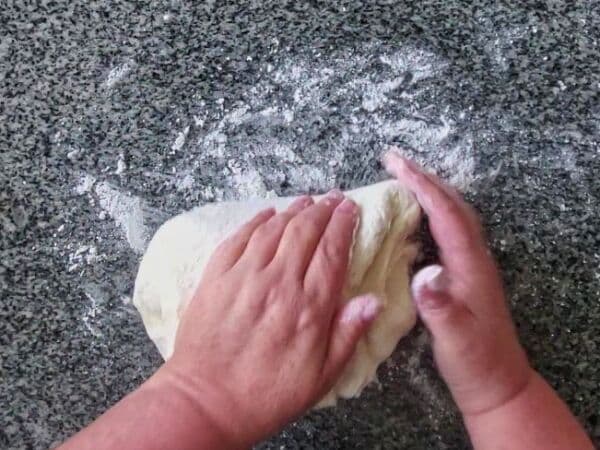 kneading dough on well floured granite countertop.
