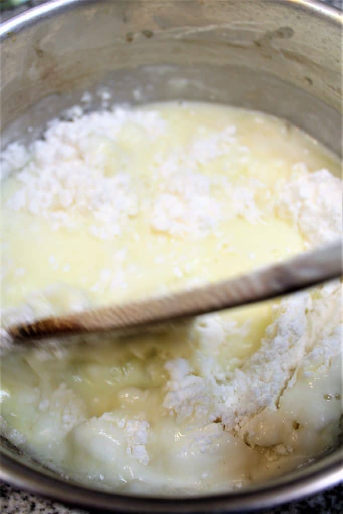 making the choux paste by adding the flour