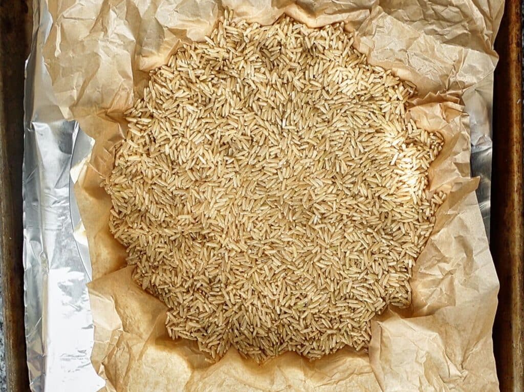 pie crust lined with crumpled brown parchment and filled with rice for parbaking.