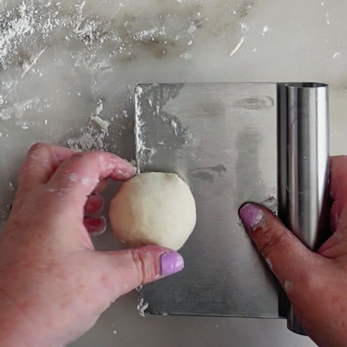 picking shaped roll up using a stainless steel bench scraper.