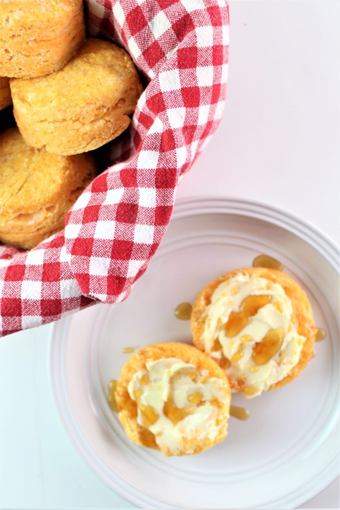 gluten free sweet potato biscuit split open and spread with butter and honey