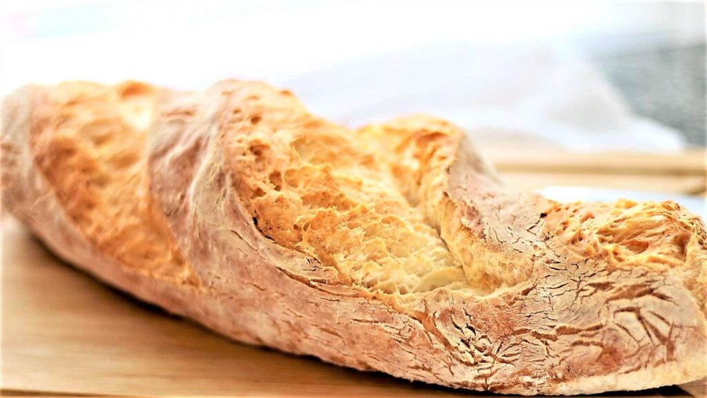 landscape view of whole baguette on cutting board