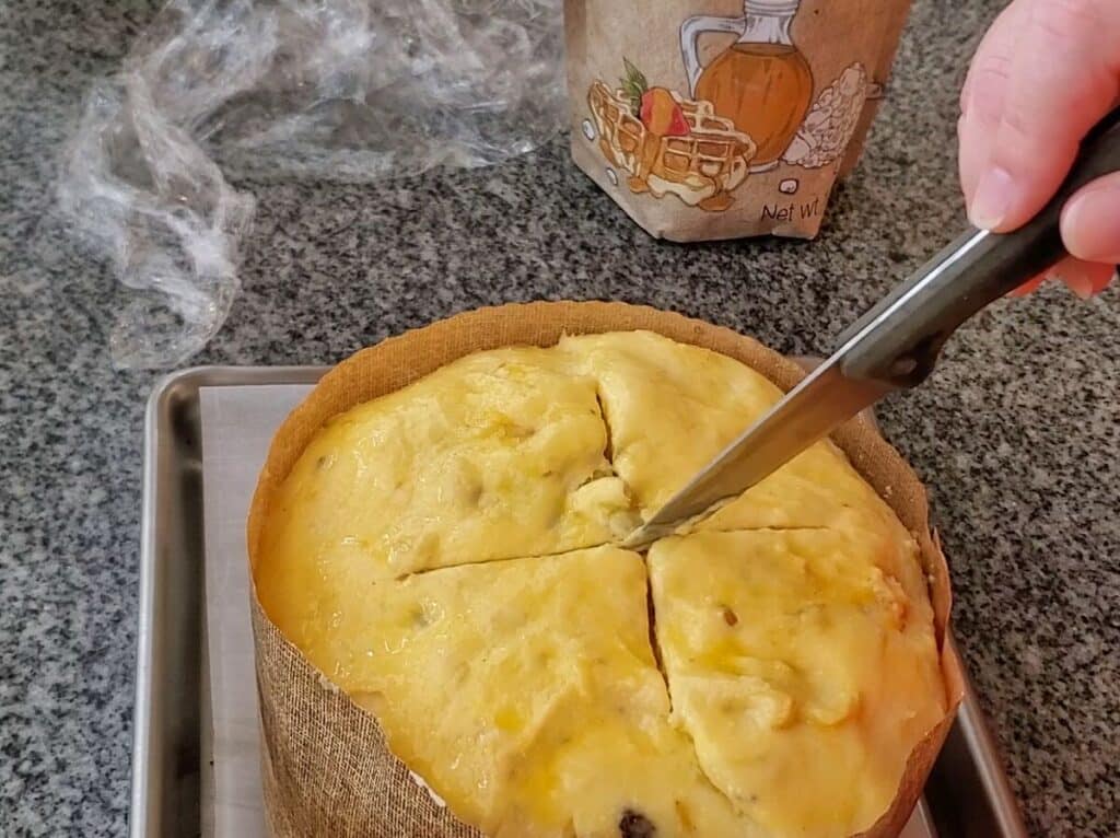 slashing top of panettone with small knife.