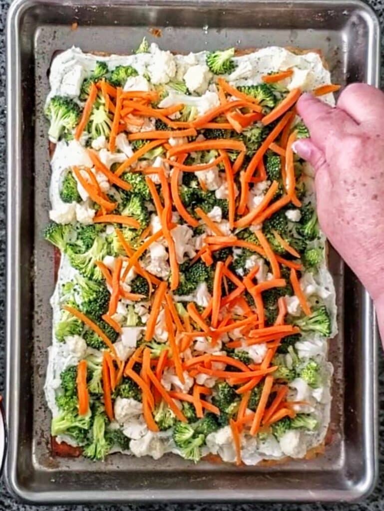 adding carrot shreds on top of cauliflower.