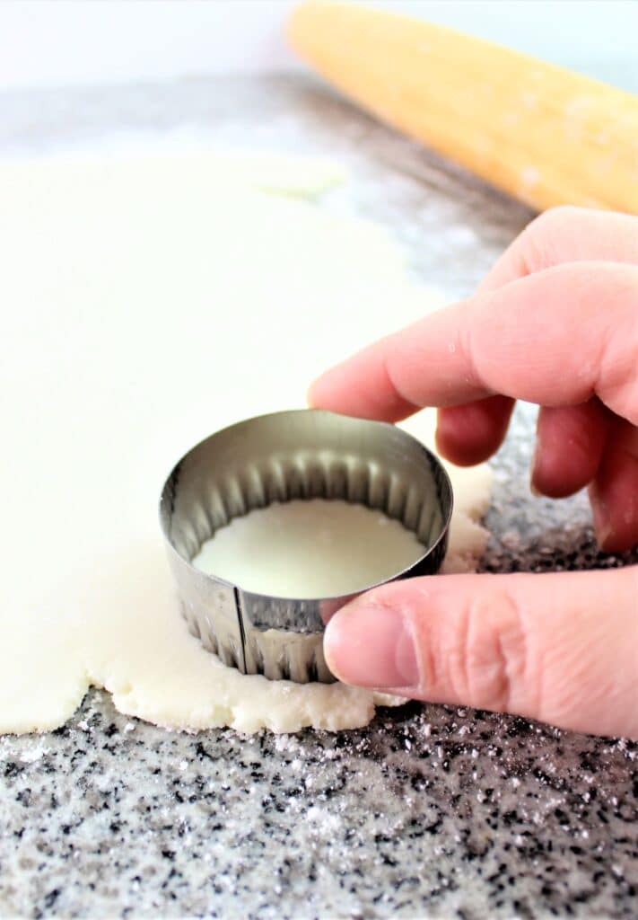 cutting out the ritz crackers with small fluted biscuit cutter