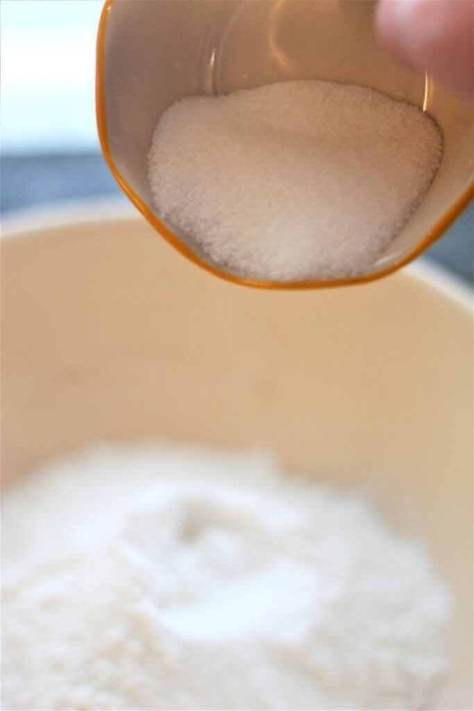 adding sugar to flour