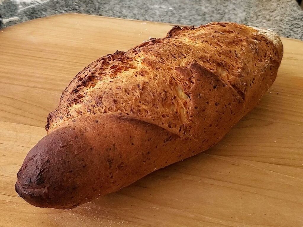 whole batard load of italian bread on wooden pizza peel