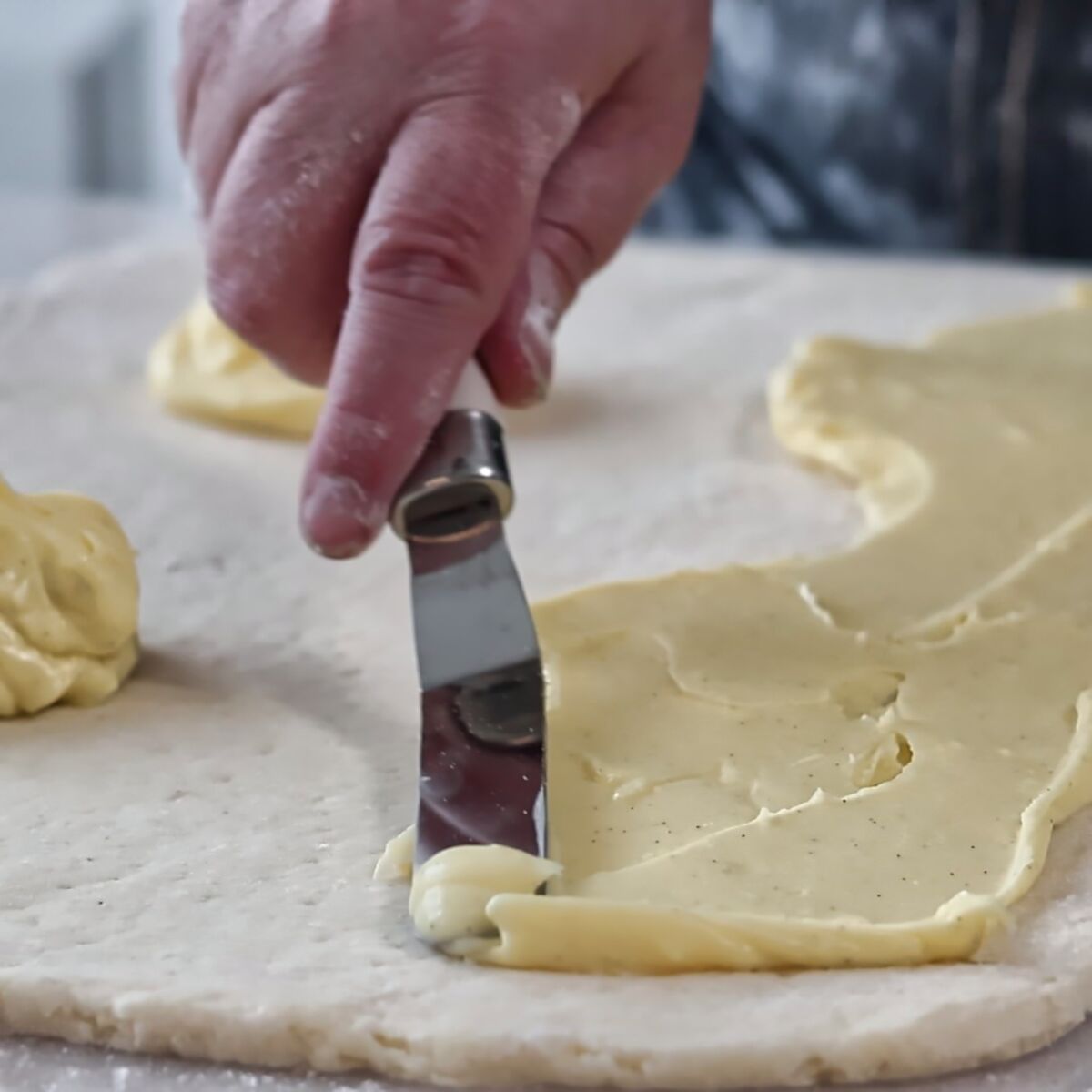 spreading pastry cream onto sweet dough.