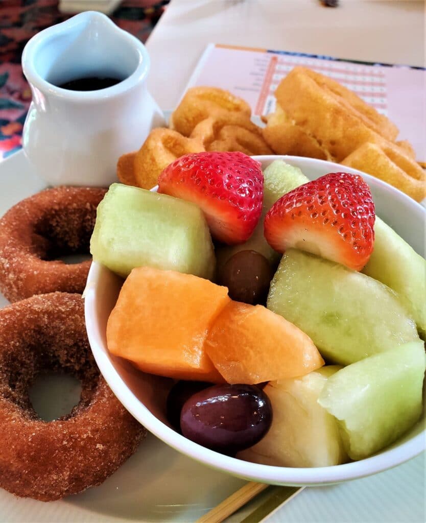 fruit in a bowl with donuts and Mickey waffles on the side