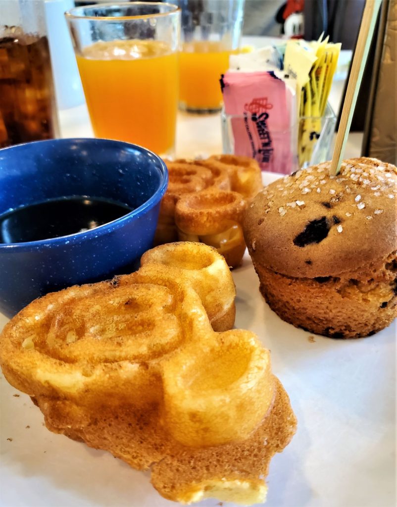 mickey waffles, syrup, and blueberry muffin
