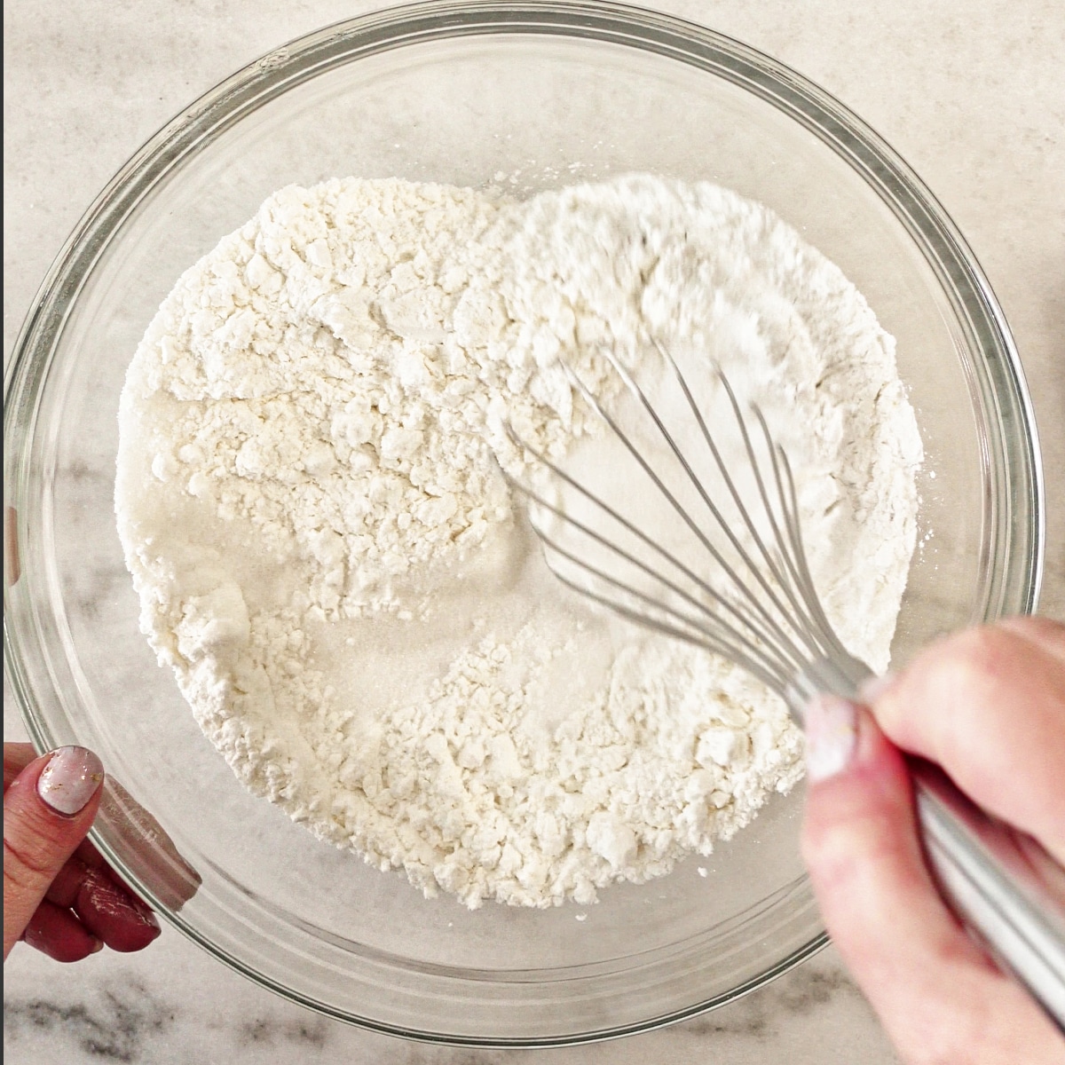 whisking dry ingredients in large glass bowl.