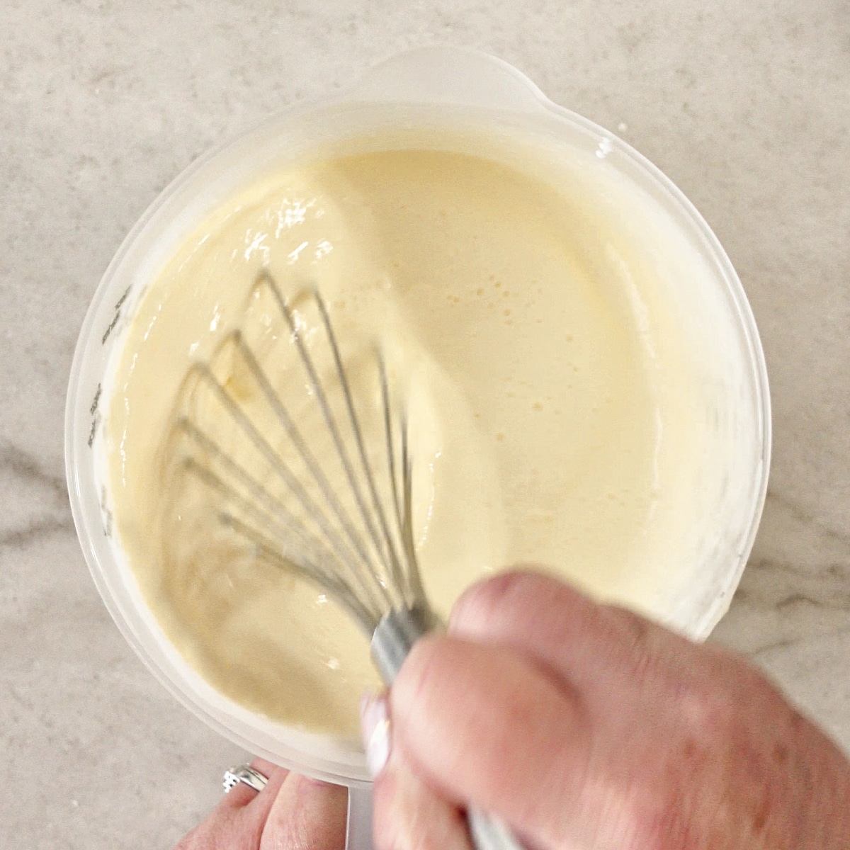 whisking wet ingredients in large plastic measuring cup.