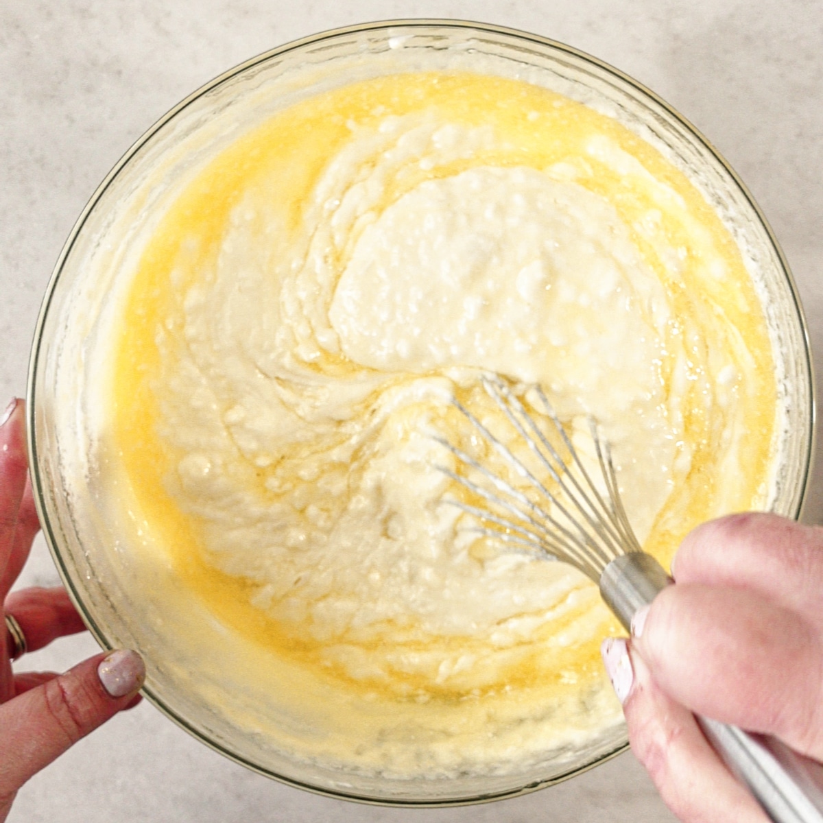 whisking melted butter into waffle batter.