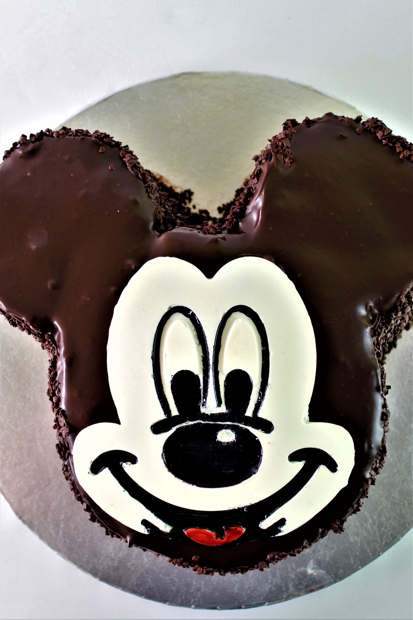 gluten free mickey mouse chocolate cake on round silver platter