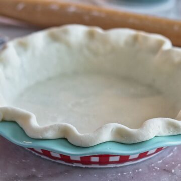 pie crust in blue and red checked pie plate.