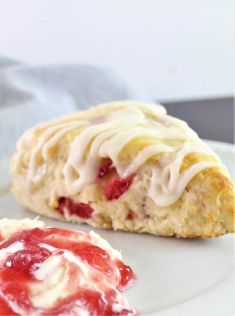 gluten free strawberry scone on plate with clotted cream and jam