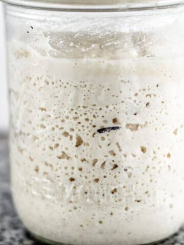 landscape view of mason jar filled with active gluten free sourdough starter.