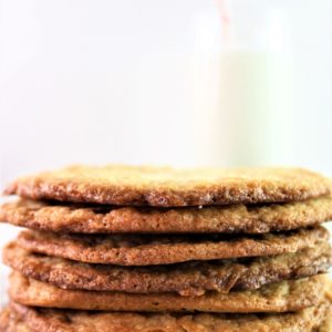 gluten free toffee cookies stacked in front of a glass of milk