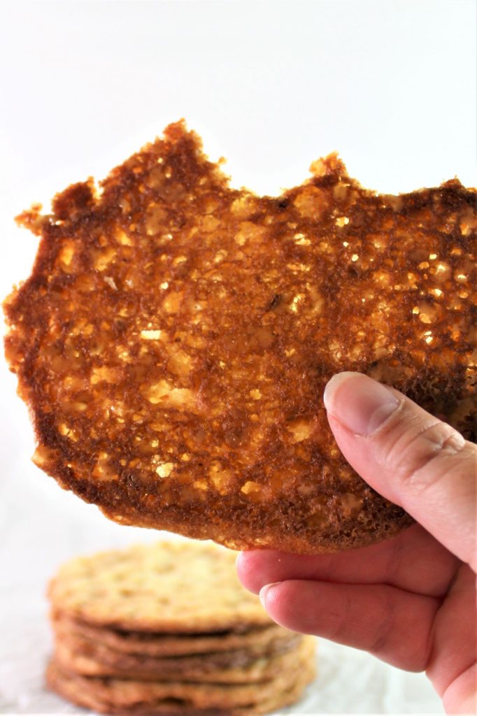 crispy cookie held up in hand with bites taken out of it