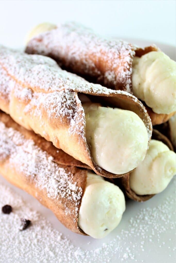 gluten free cannoli stacked on white cake plate