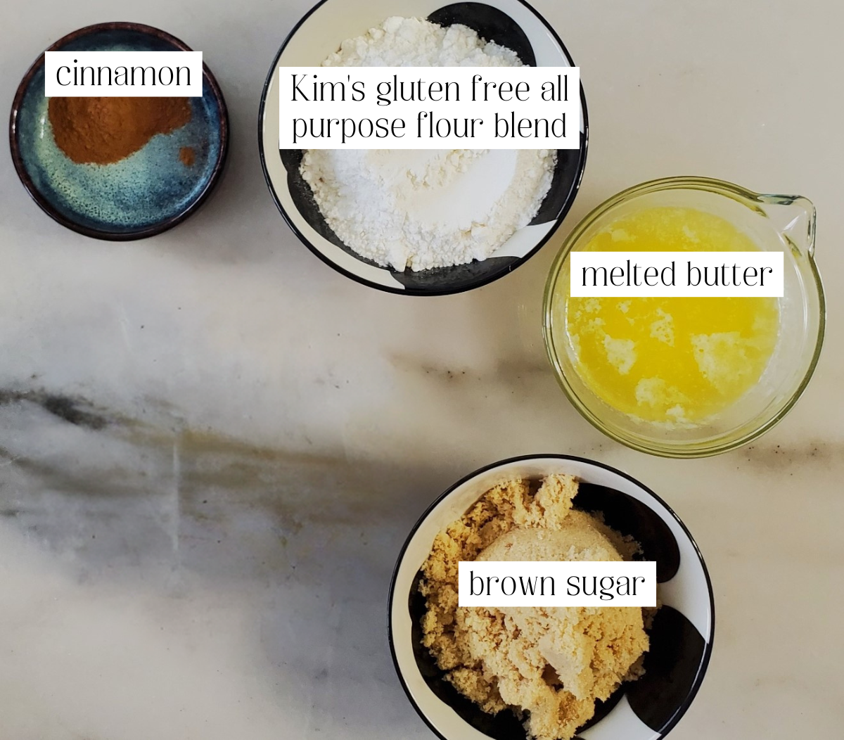 ingredients for crumble measured out and labeled on white marble counter.