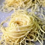 homemade gluten free pasta in individual nests on a sheet tray