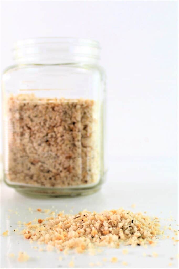 gluten free breadcrumbs in a glass jar and spilled out on a counter