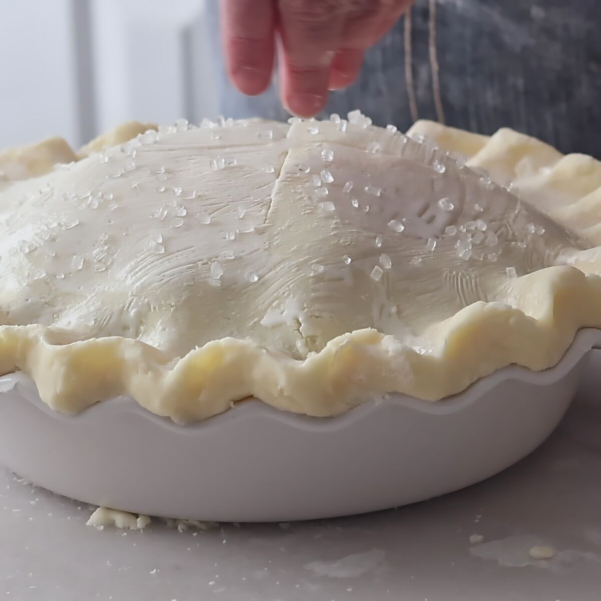 sprinkling top pie crust with large sugar crystals.