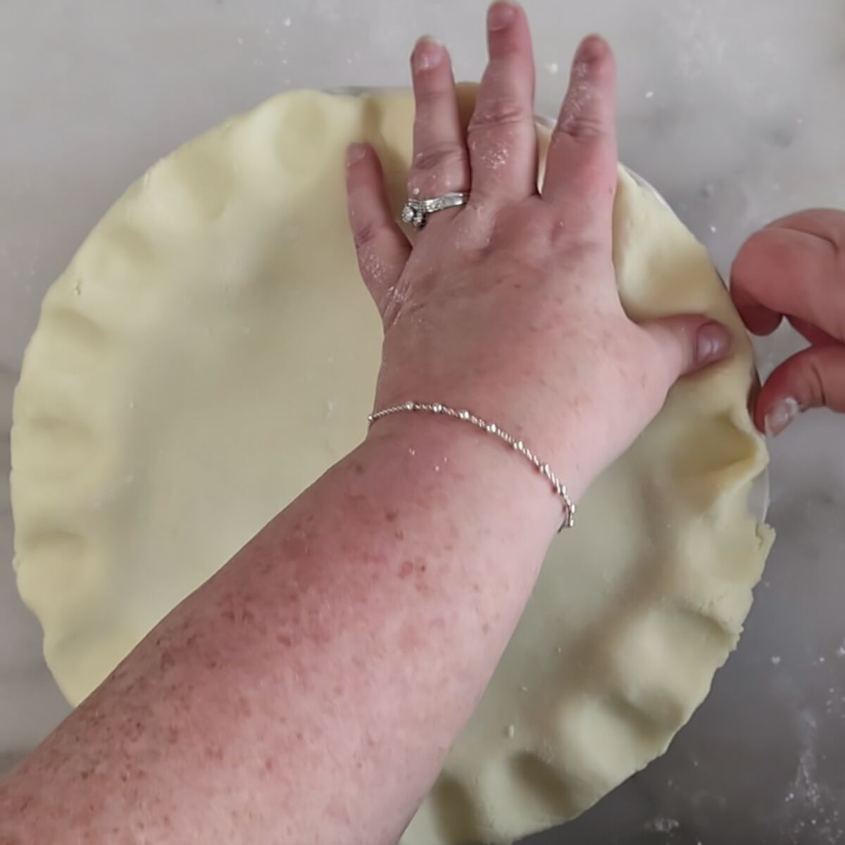 crimping pie crust with fingers.