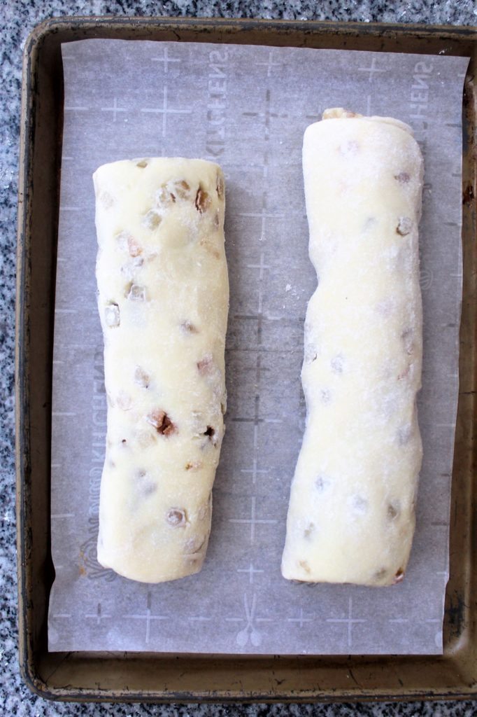 rolls of filled dough on a parchment lined baking sheet