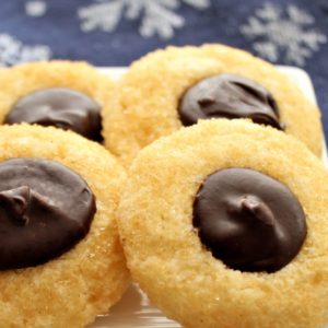 chocolate thumbprint cookies on white square plate with blue snowflake napkin