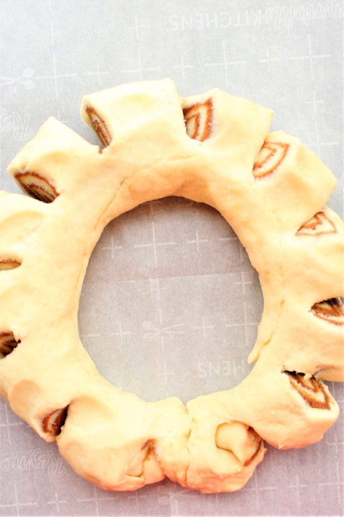 cuts made into dough roll to resemble wreath
