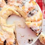 gluten free cinnamon roll wreath on white cake stand over red checked napkin