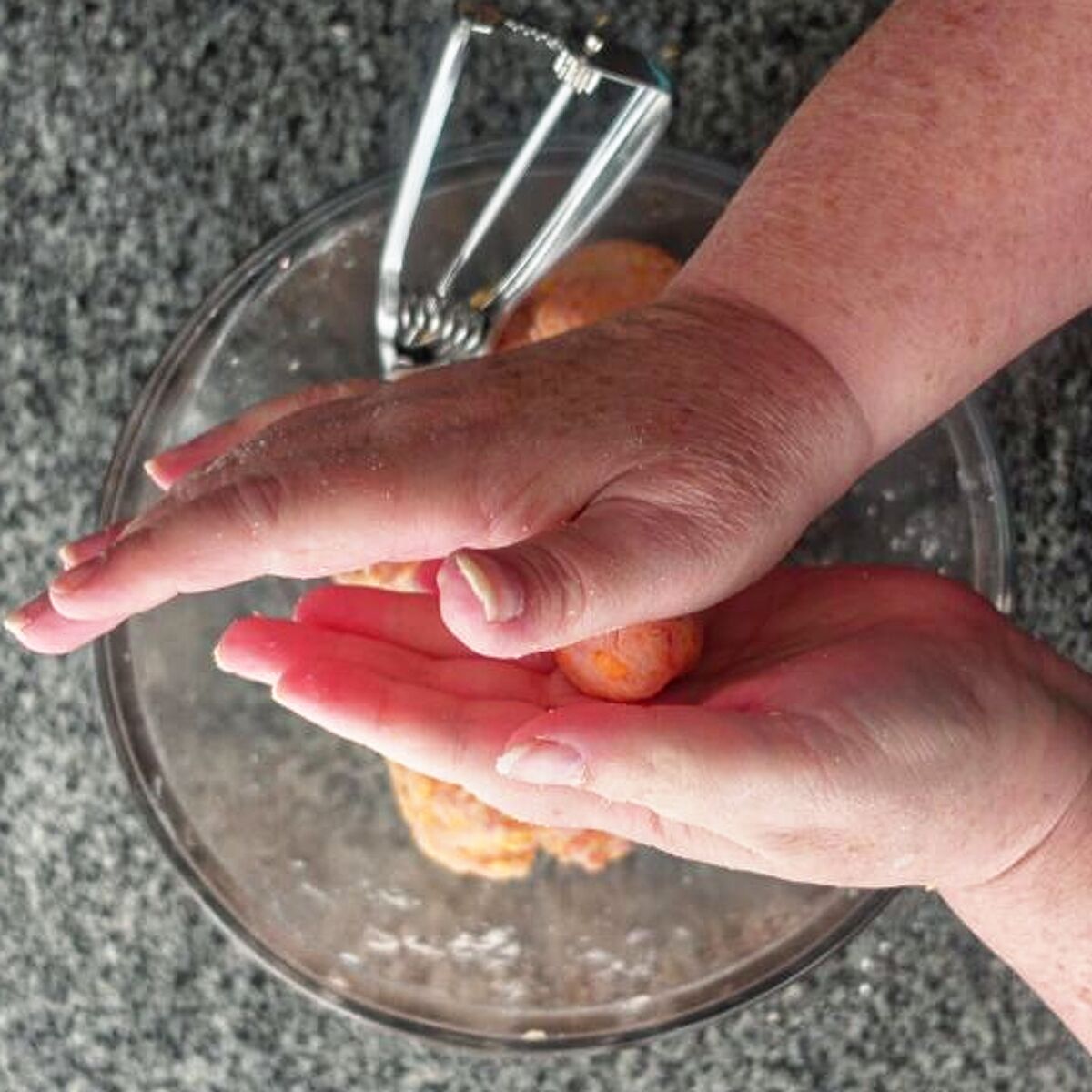 rolling sausage ball mixture into balls between two hands.