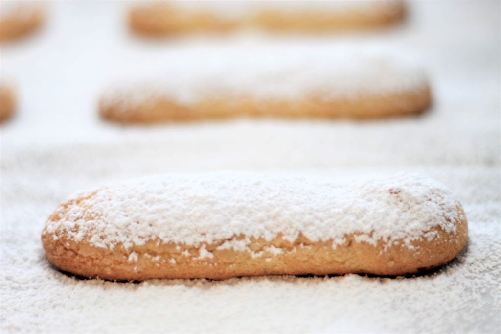 ladyfingers on baking sheet covered in powdered sugar